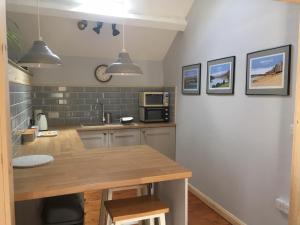 a kitchen with a table and a microwave at Hendre Cennin in Criccieth