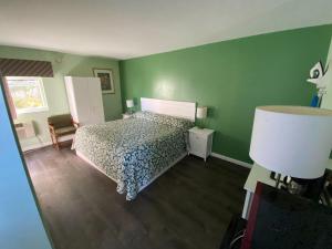 a bedroom with a bed and a green wall at Town House Inn in Oneonta