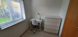 a desk with a chair and a lamp next to a window at FN City Bungalow in Friedrichshafen