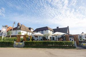 una fila de casas con una valla y árboles en The Potters Arms en Amersham