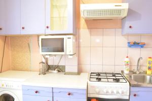 a small kitchen with a stove and a microwave at Квартира на Дарвина in Tver