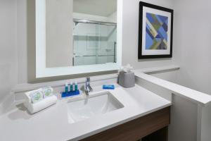 uma casa de banho branca com um lavatório e um espelho em Holiday Inn Express & Suites Bryan - College Station, an IHG Hotel em Bryan