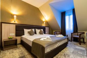 um quarto de hotel com uma cama com toalhas em Hotel IZVOARE Caciulata em Călimăneşti
