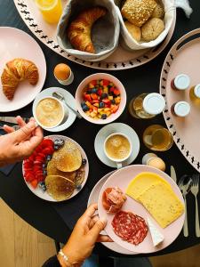 a table topped with plates of food and plates of pastries at B&B De Stuifduinen in Wetteren