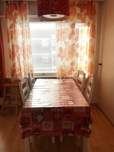 ein Esszimmer mit einem Tisch, Stühlen und einem Fenster in der Unterkunft Apartment Vuorikatu 35 Mummola in Kuopio
