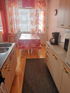 eine Küche mit einem Waschbecken und einem Tisch mit einem Tisch in der Unterkunft Apartment Vuorikatu 35 Mummola in Kuopio
