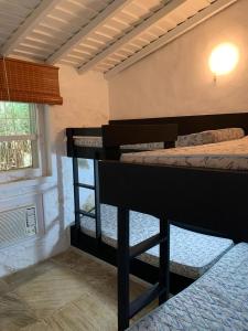 two bunk beds in a room with a window at Casa no Parque da Costa do Sol in Arraial do Cabo