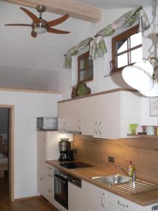 Il comprend une cuisine équipée d'un évier et d'un ventilateur de plafond. dans l'établissement Gästehaus Gaisalpe, à Fischen im Allgäu