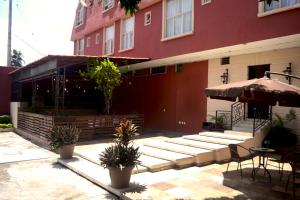 Jalisco的住宿－Hotel Aztlan，一座带桌子和遮阳伞的庭院的建筑