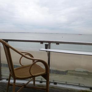 a chair sitting on a balcony overlooking the water at Hotel De Leugenaar in Vlissingen