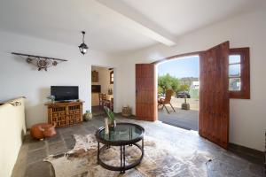 un soggiorno con tavolo e porta aperta di Las Esterlicias ( Villa Rural Ecológica ) a Teror