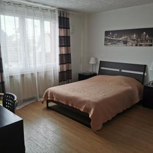 - une chambre avec un lit et une grande fenêtre dans l'établissement Résidence Hôtel Les Joséphines, à Rueil-Malmaison