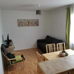 a living room with a table and a couch at Résidence Hôtel Les Joséphines in Rueil-Malmaison