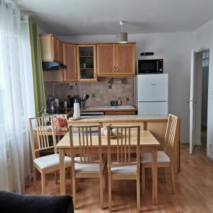 une cuisine avec une table en bois et des chaises ainsi qu'une salle à manger dans l'établissement Résidence Hôtel Les Joséphines, à Rueil-Malmaison