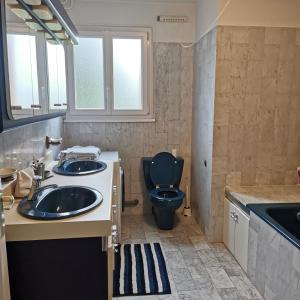 uma casa de banho com um WC azul e um lavatório. em Résidence Hôtel Les Joséphines em Rueil-Malmaison