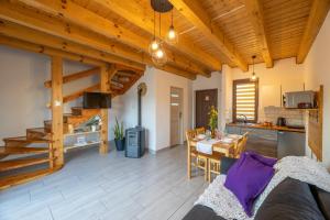 a living room with wooden ceilings and a table and a kitchen at Domek Pod Holicą in Ustrzyki Dolne