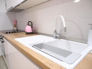 a kitchen with a sink and a pink kettle on a counter at Apartmani Igor in Makarska +25 photos