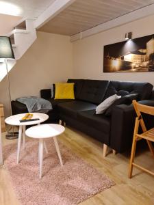 ein Wohnzimmer mit einem schwarzen Sofa und einem Tisch in der Unterkunft Amber Hostel in Krakau