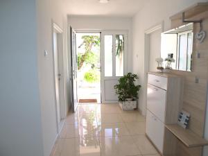 a kitchen with a door open to a hallway with a plant at Apartmani Igor in Makarska