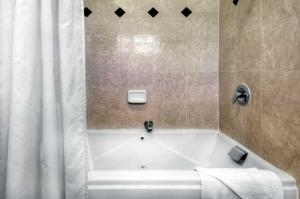 a bathroom with a bath tub with a shower curtain at County Inn in Mountain View