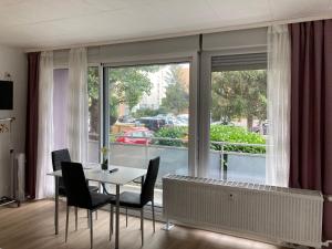 a dining room with a table and chairs and a large window at Studios Lora RM 860 in Saint-Louis