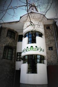 a white building with a staircase in front of it at Hotel Tivoli in Sovata