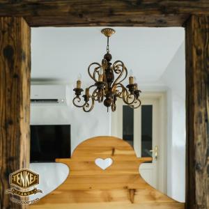 a chandelier hanging over a table with a heart carved into it at Tenkes Fogadó és Vendégház Harkány in Harkány