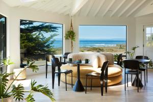 a living room with a couch and tables and a view of the ocean at White Water in Cambria