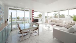 una sala de estar con muebles blancos y ventanas grandes. en You Stylish Beach Apartments, en Barcelona