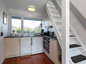 a kitchen with a spiral staircase in a house at 5 person holiday home in V ggerl se in Marielyst
