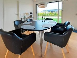 una sala da pranzo con tavolo e sedie nere di 6 person holiday home in Slagelse a Slagelse