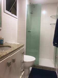 a bathroom with a toilet and a glass shower at Apartamento Parque Olímpico in Rio de Janeiro