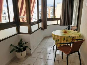 einen Tisch und Stühle in einem Zimmer mit Fenstern in der Unterkunft Apartamento centro de Nerja in Nerja