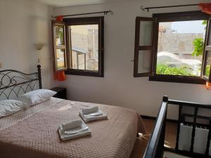 een slaapkamer met een bed met 2 handdoeken en 2 ramen bij Chris Αpartments Old Town in Rhodos-stad