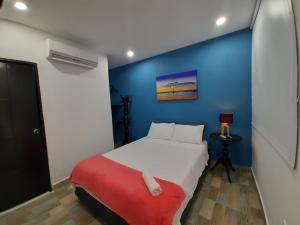 a bedroom with a bed and a blue wall at Hotel Sunset Beach in Cartagena de Indias