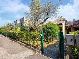 una fila di pali verdi di fronte a una casa di Belvilla by OYO Casa Mon ga a Moniga