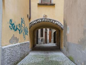 an alley with an archway in a building with graffiti at Belvilla by OYO Ai tetti in Intra