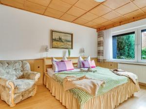 ein Schlafzimmer mit einem Bett und einem Stuhl in der Unterkunft Flat in Ilsenburger Harz near the ski area in Ilsenburg