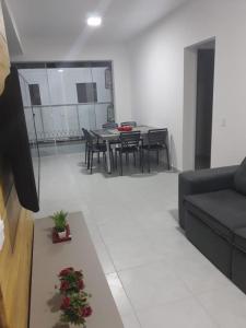 uma sala de estar com um sofá e uma mesa em Lindo apartamento completo em Ubatuba em Ubatuba