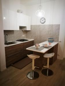 eine Küche mit einer Kücheninsel mit zwei Barhockern in der Unterkunft Central 2 bedrooms 2 bathrooms in Ancona