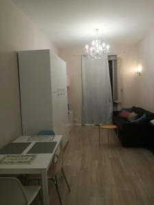 een woonkamer met een zwarte bank en een kroonluchter bij Central 2 bedrooms 2 bathrooms in Ancona