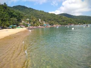 una playa con un grupo de barcos en el agua en Nena's Suítes en Praia de Araçatiba