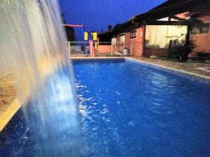 un tobogán de agua en una piscina por la noche en Pousada Cravo & Canela, en Campos do Jordão