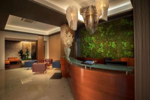 una hall con bar, sedie e lampadari a braccio di Best Western Plus Hotel Spring House a Roma