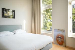a bedroom with a bed and a large window at Hotel 171 in Rotterdam
