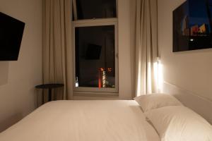 a bedroom with a white bed and a window at Hotel 171 in Rotterdam