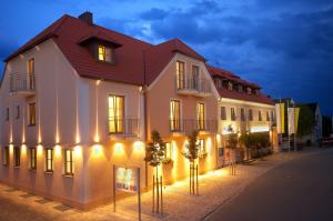 ein großes weißes Gebäude mit Lichtern an einer Straße in der Unterkunft Landgasthof Euringer in Beilngries