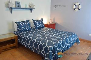 a bedroom with a blue and white comforter on a bed at Abel's Villa by FMI Rentals in Puerto Pe&ntilde;asco