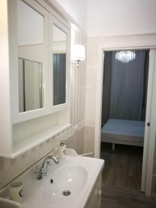 een witte badkamer met een wastafel en een spiegel bij Central 2 bedrooms 2 bathrooms in Ancona