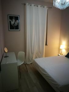 a bedroom with a bed and a table and a chandelier at Central 2 bedrooms 2 bathrooms in Ancona